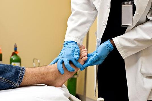 doctor checking out persons foot